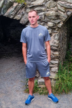 MaKalu Grey Activewear Fitness T-shirt and Short set worn by man outdoors with reflective logo and blue sneakers